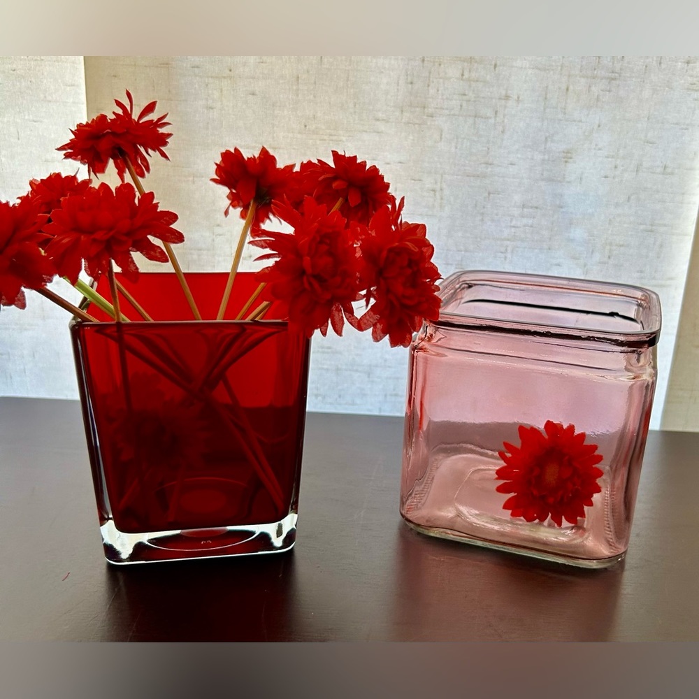 Two flower vases, containers and/or candle holders.